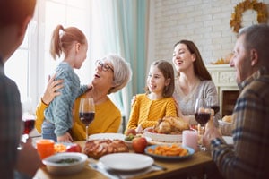 A white family laughing around a holiday table